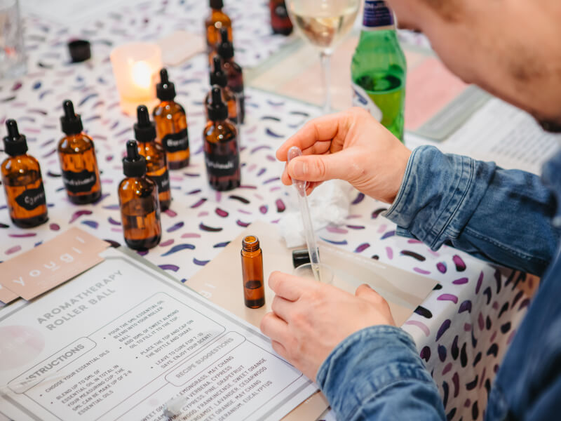 A close up of a man blending scent with a pipette